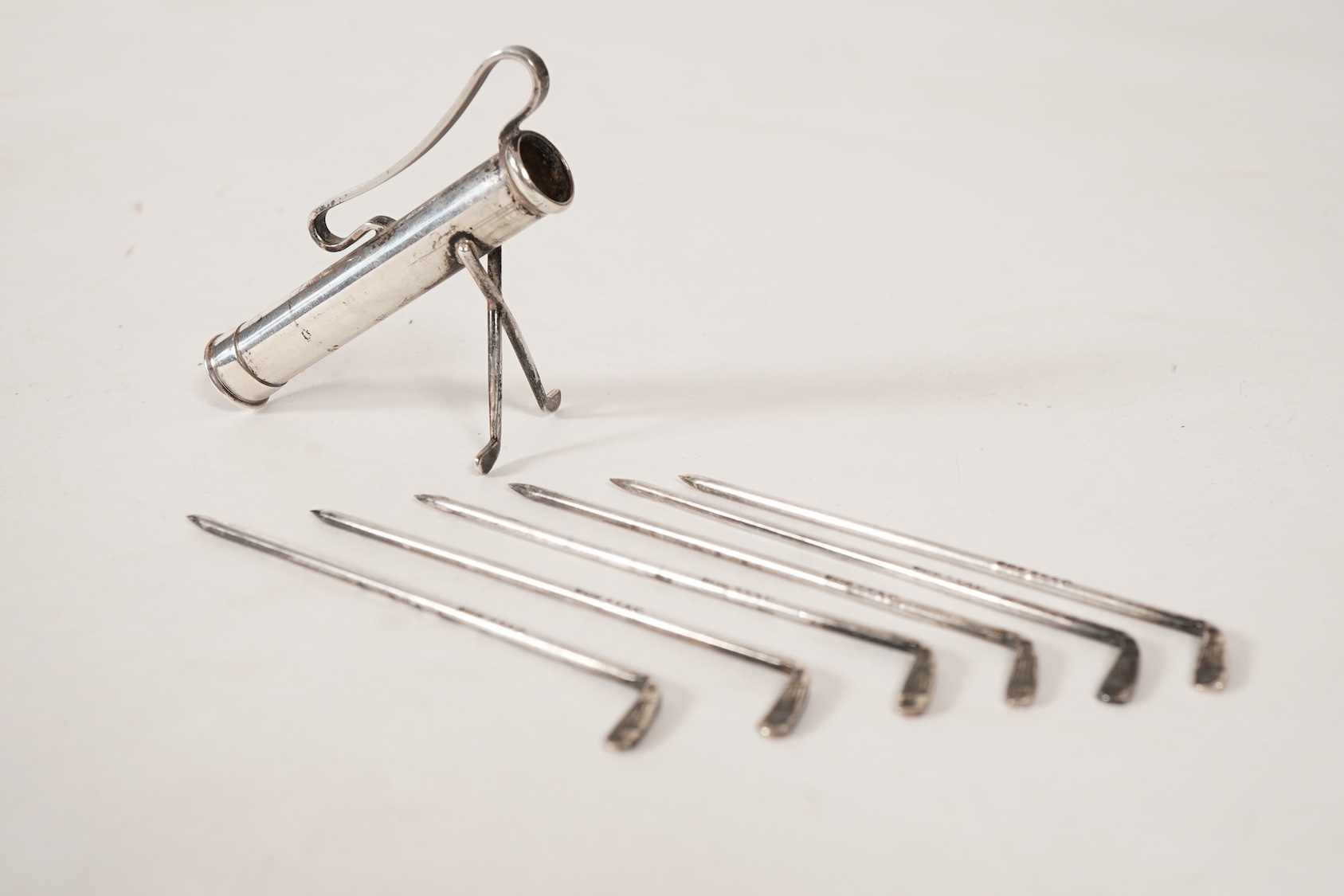 A set of six George V novelty silver cocktail sticks with holder, modelled as a golf bag with clubs, by John Nowill & Sons